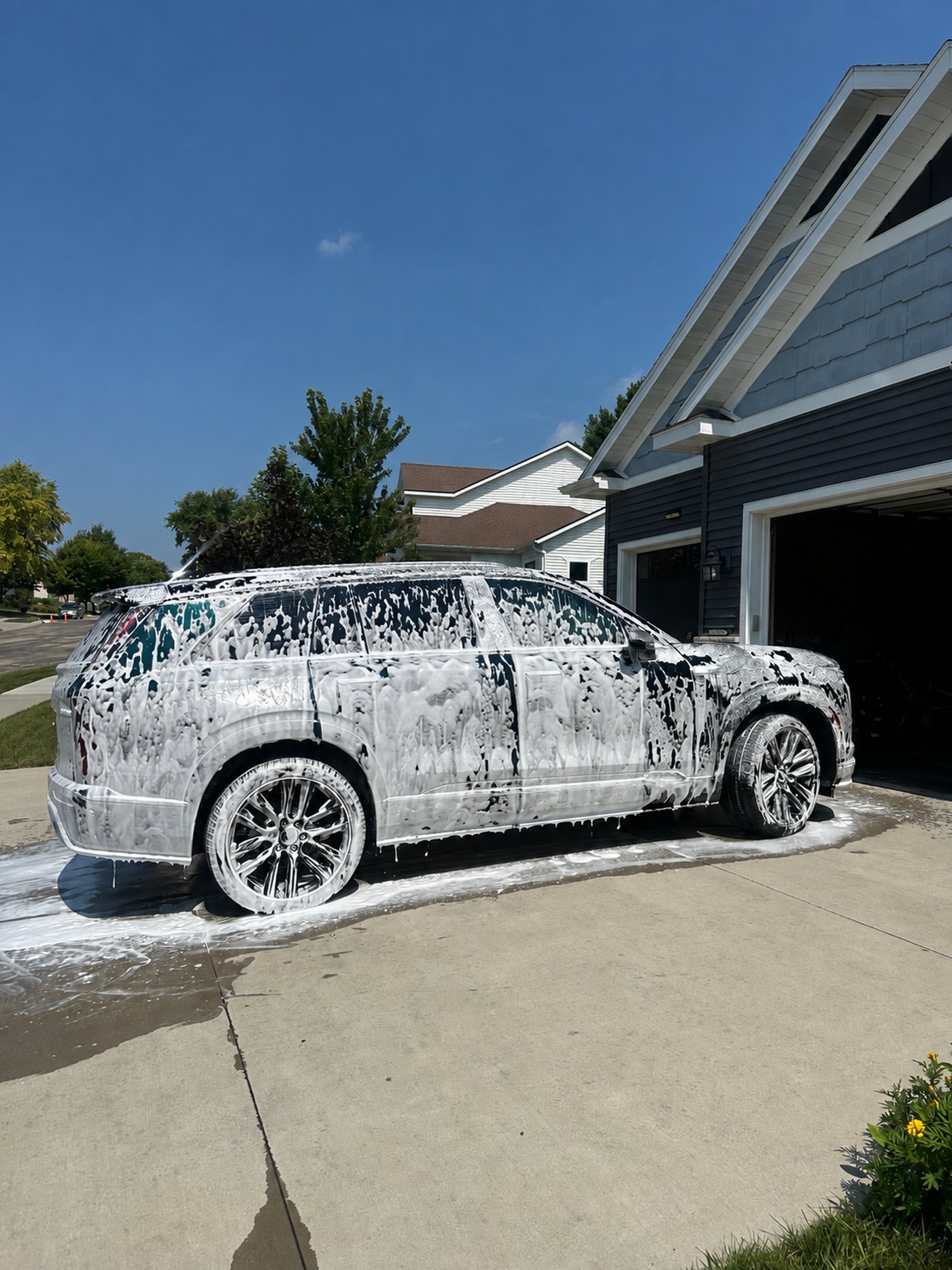 An SUV covered in foam during a wash
